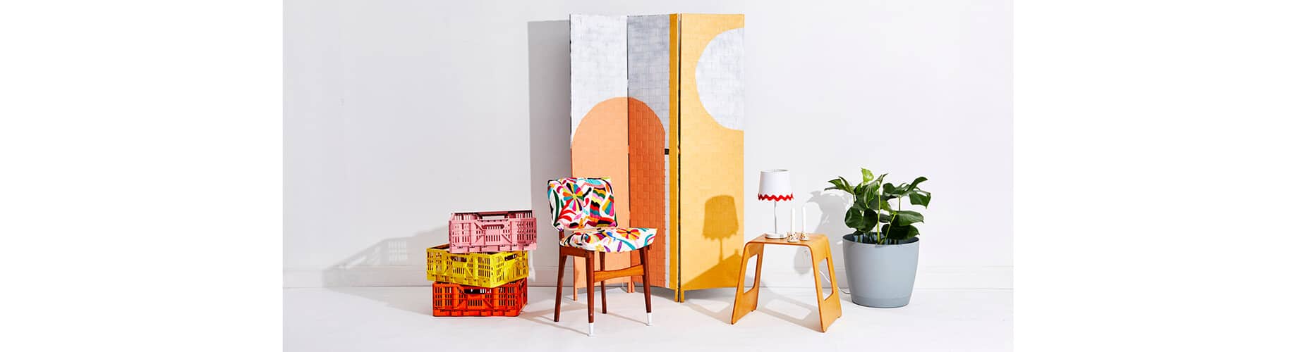 a colourful still life photography of crates, chair, lamp, and room divider