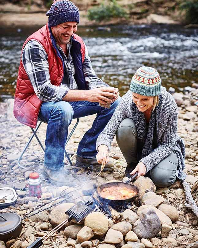 two people cooking outdoors
