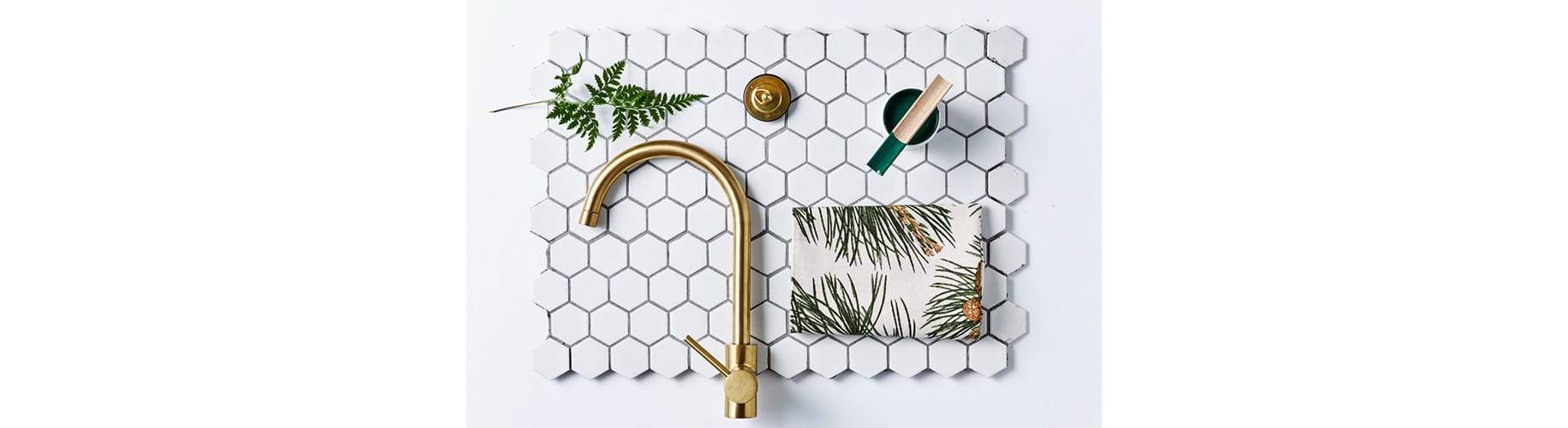 flat lay photography of a gold faucet and fern