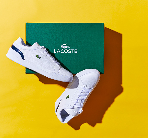 white Lacoste shoes on green box